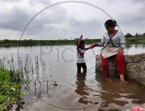 Image of Closeup Of Beautiful Indian Kid And Mother Playing In A Pond Of Village At Bevoor ...