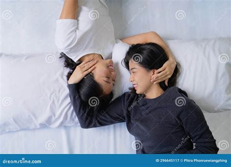 Beautiful Asian Lesbian Couple With Happy Smiles Lying On Bed And Looking Together At Home Stock