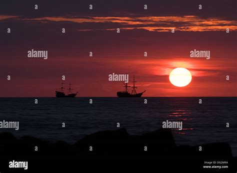 Sunset at the sea with ships Stock Photo - Alamy