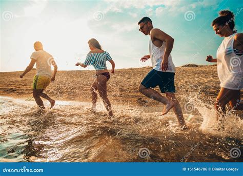 Grupo De Personas Corriendo En La Playa En El Mar Foto De Archivo