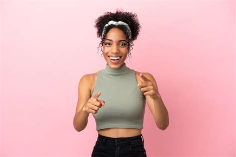 Jovem Latina Isolada Em Um Fundo Rosa Surpresa E Apontando Para A Frente Foto Premium