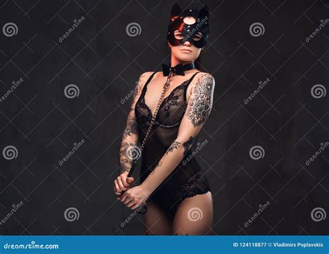 Woman Wearing Black Lingerie In BDSM Cat Leather Mask And Accessories Posing On Dark Background