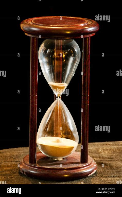 Old Wooden Sand Timer Almost Out Of Time On Old Cloth Surface Against A