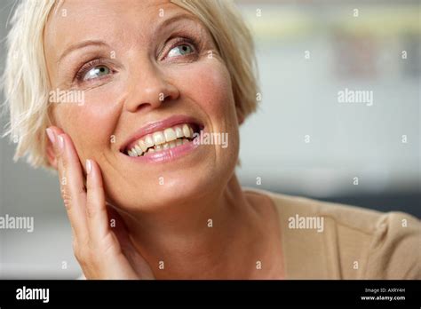 Mature Woman With Blond Hair Touching Her Cheek Close Up Stock Photo Alamy