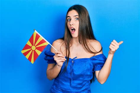 Joven Adolescente De Brunette Sosteniendo La Bandera Macedonia Apuntando El Pulgar Hacia El Lado