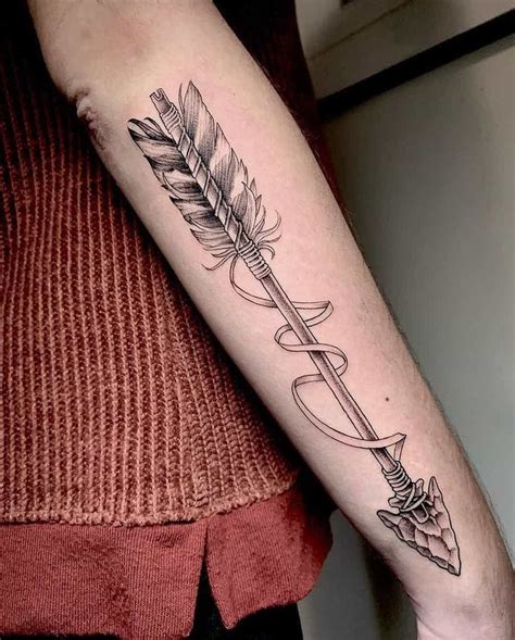 A Woman S Arm With A Feather And Arrow Tattoo On The Left Inner Forearm