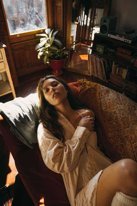 A Boudoir Photo Shoot Of A Woman On A Beige Ledge Near A Window Wearing Lingerie By Lexi Brown