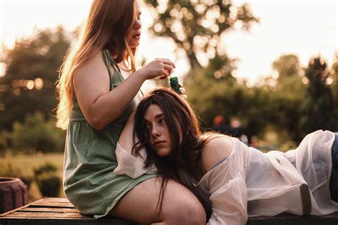Lesbian Couple Playing With Bubbles While Relaxing In Park In Summer Photograph By Cavan