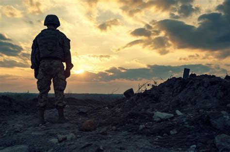 Premium Photo | Silhouette of a soldier in a military uniform at sunset