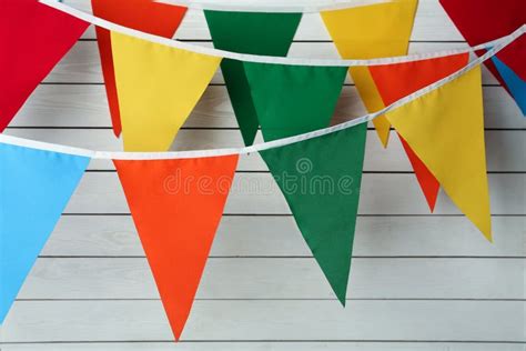 Buntings With Colorful Triangular Flags On White Wooden Background