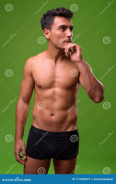 Young Handsome Hispanic Man Shirtless Against Green Background Stock