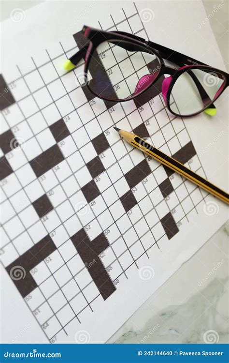 Pencil And Glasses On The Paper With Solved Crossword Puzzle Stock