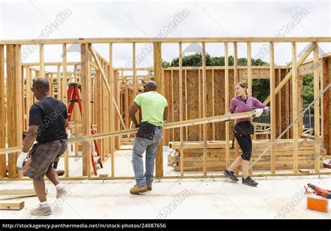 Volunteers Carrying Lumber At Construction Site Lizenzfreies Foto