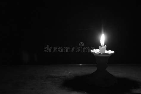 Blazing Light Of Short Candle On Candlestick In The Dark Stock Image