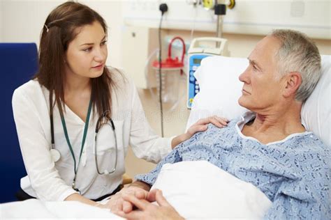 Serious Female Doctor Sitting by Male Patient S Bed Stock Image - Image ...