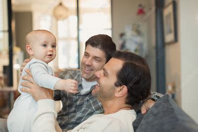 Male Gay Parents Holding Baby Son On Sofa Stock Image F018 5531 Science Photo Library