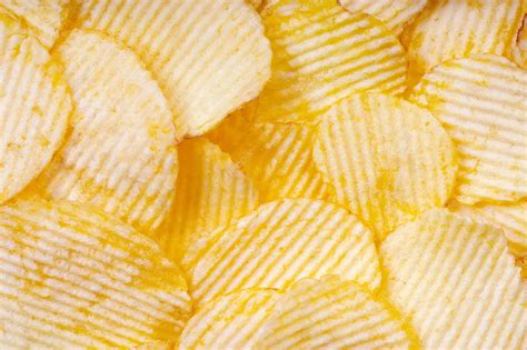 Premium Photo Yellow Crispy Ridged Potato Chips Close Up Food Background