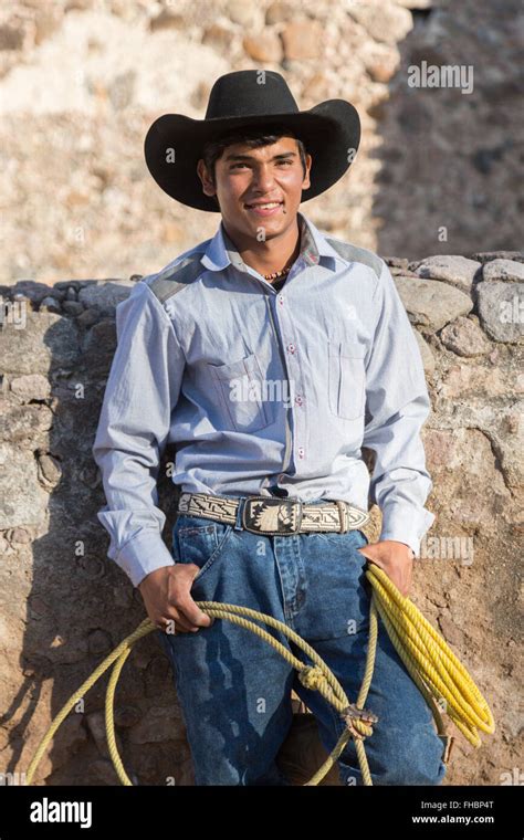 A Mexican charro or cowboy poses in cowboy hat and lasso at a hacienda ...