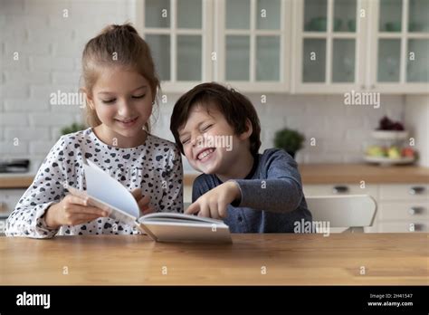 Happy little children reading funny story in paper book Stock Photo - Alamy