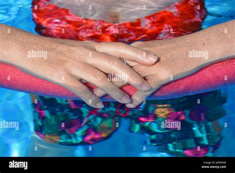 Keeping Cool Woman Standing In A Swimming Pool Holding A Pool Noodle