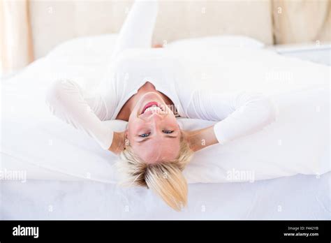 Smiling Blonde Woman Lying On The Bed Stock Photo Alamy