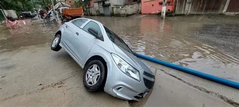 Carro é engolido por buraco em rua alagada após chuva em Niterói