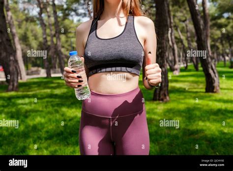 Brunette Sportive Woman Wearing Black Sports Bra Standing On City Park