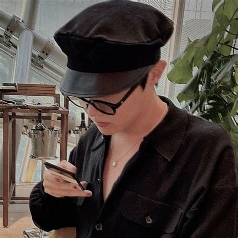 A Man In A Hat Looking At His Cell Phone