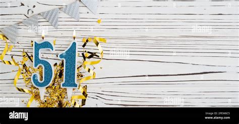Number 51 blue celebration candle on white wooden background. Happy