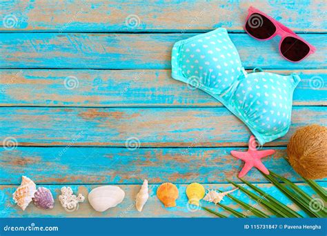 Summer Background With Bikini Sunglasses Coconut Starfish Coral And Shells On Blue Wooden