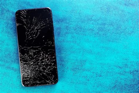 Premium Photo A Black Phone With A Broken Screen Lies On A Turquoise