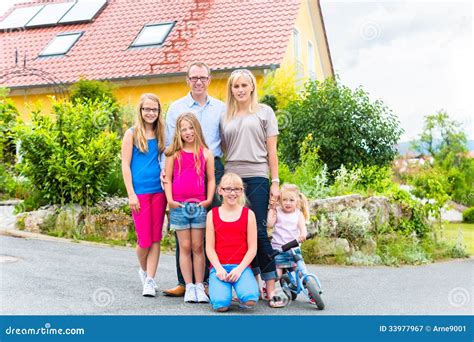 Famille Heureuse Devant Leur Maison Photographie Stock Libre De Droits