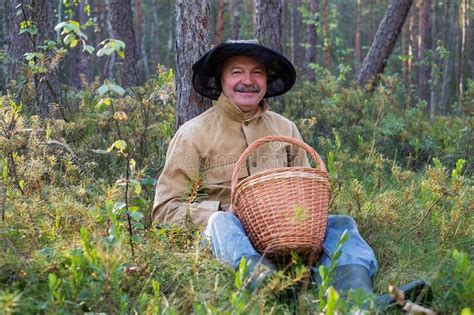 Portrait Of Relaxed Mature Man Sitting In The Forest With Basket Stock Photo Image Of