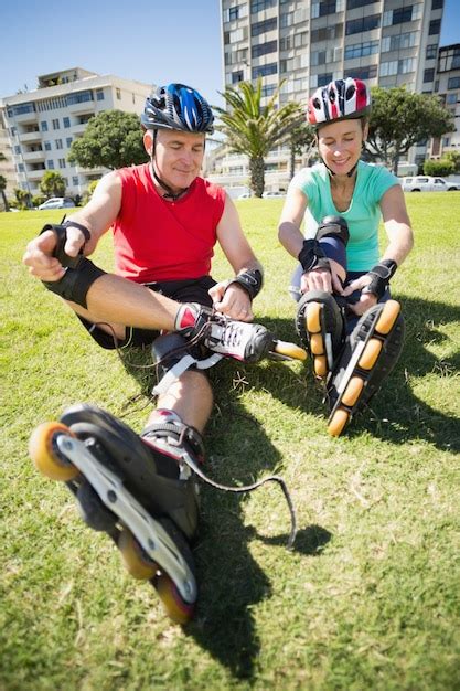 Premium Photo Fit Mature Couple Tying Up Their Roller Blades On The Grass