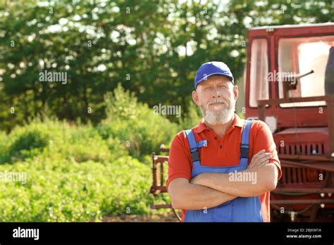 Mature Farmer Standing Near Tractor Stock Photo Alamy