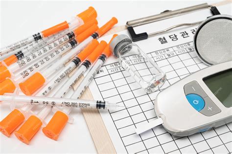 Glucometer 및 흰색 배경에 인슐린 주사기 채혈 장치 테스터 스트립 | 프리미엄 사진