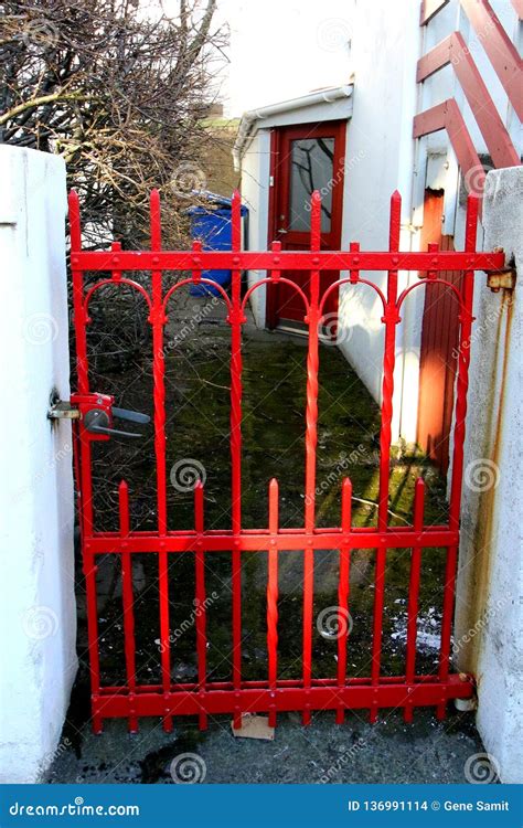 The Red Gate Lines The Entrance To This European House Stock Photo