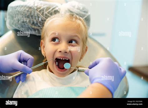 Adorable child with open mouth on examination at the dentist. The ...