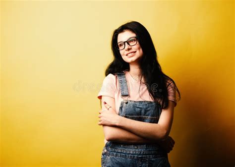 Beautiful Smiling Brunette Girl Wearing Glasses In Denim Overall Posing