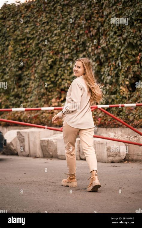 Une Jolie Jeune Femme Blonde Marche Dans La Rue Elle Porte Un Jean Et Une Chemise Beige Belle