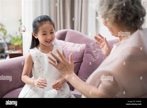 Happy Grandmother And Granddaughter Playing Clapping Game Stock Photo