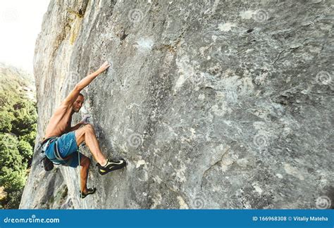 Strong Muscular Man Rock Climber With Naked Torso Dynamically Climbing