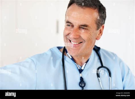An Experienced Mature Doctor Smiling Against White Closeup Portrait Of Experienced Mature