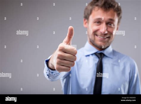 Smiling Motivated Man Giving A Thumbs Up Gesture To Show His Approval