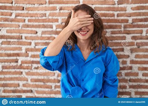 Beautiful Brunette Woman Standing Over Bricks Wall Smiling And Laughing With Hand On Face
