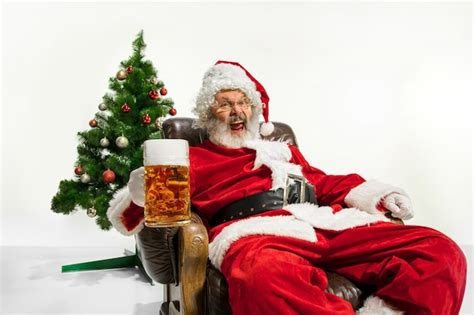 Premium Photo Santa Claus Drinking Beer Near The Christmas Tree