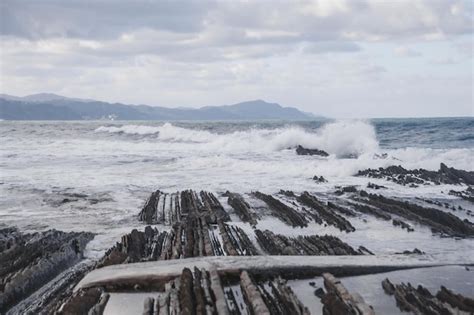 Premium Photo A Large Wave Crashing Into A Rocky Shore