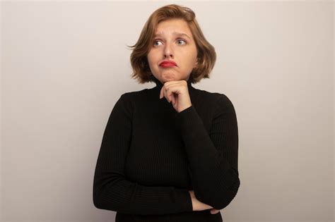 Triste Jeune Fille Blonde Mettant La Main Sur Le Menton En Regardant Le Côté Isolé Sur Fond