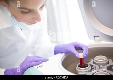 Scientist In Lab Coat Putting Vial With Sample Into Autosampler Of Hplc