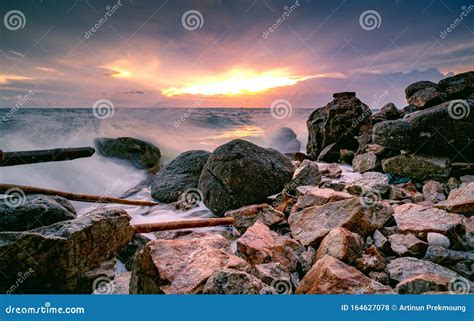 A água Do Oceano Se Espalha Na Praia Do Rock Belos Céus E Nuvens Do